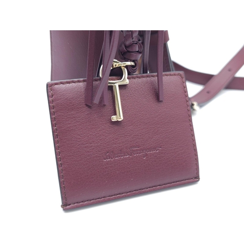 468 - Salvatore Ferragamo Leather Burgundy Shoulder Bag.
Comes with tasselled and woven vanity mirror with... 