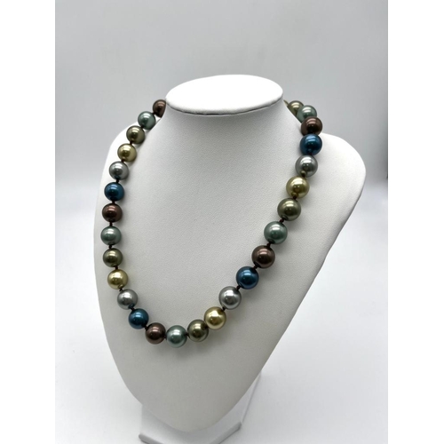 654 - A Seductive Four Colour South Sea Bead Necklace. Grey, blue, gold and silver 12mm shell beads. Heart... 