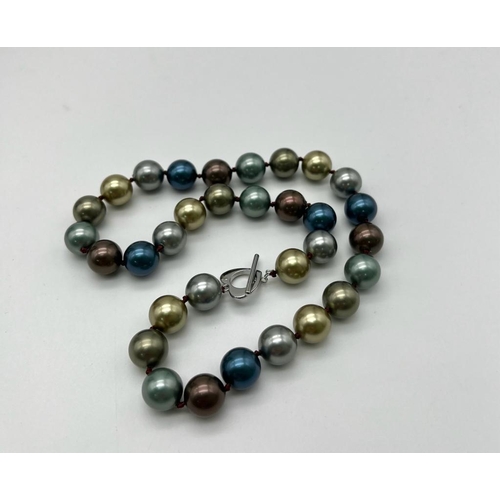 654 - A Seductive Four Colour South Sea Bead Necklace. Grey, blue, gold and silver 12mm shell beads. Heart... 