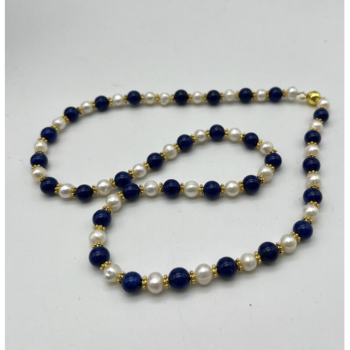 732 - A Lapis Lazuli and Cultured Pearl Necklace. 7/8mm lapis and pearls. Gilded spacers and clasp. 60cm n... 