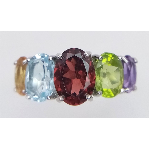 777 - An Unworn Sterling Silver Multi Gemstone Ring.
Size O. Set with Oval Cut Garnet, Topaz, Peridot, Cit... 