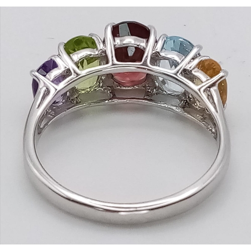 777 - An Unworn Sterling Silver Multi Gemstone Ring.
Size O. Set with Oval Cut Garnet, Topaz, Peridot, Cit... 