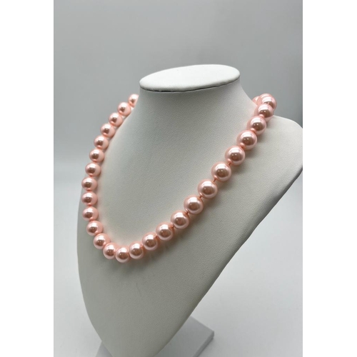 825 - A Charming Pink South Sea Pearl Shell Bead Necklace. 12mm shell beads. 44cm necklace length. Heart c... 