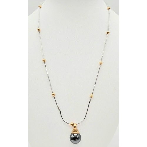 1418 - A DESIGNER 18K WHITE AND YELLOW GOLD NECKLACE SPORTING A 9K GOLD AND HEMATITE PENDANT .   13.2gms   ... 