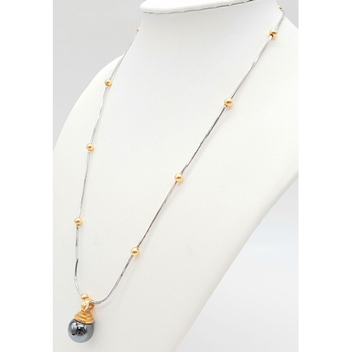 1418 - A DESIGNER 18K WHITE AND YELLOW GOLD NECKLACE SPORTING A 9K GOLD AND HEMATITE PENDANT .   13.2gms   ... 