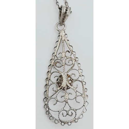 1476 - AN INTERCUT SILVER PENDANT ON A 44cms SILVER CHAIN.   5.5gms