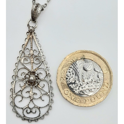 1476 - AN INTERCUT SILVER PENDANT ON A 44cms SILVER CHAIN.   5.5gms