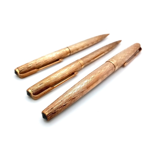 239 - A Wonderful Parker Pen 9K Gold Writing Set. Fountain, ballpoint and pencil in decorative bark-effect... 