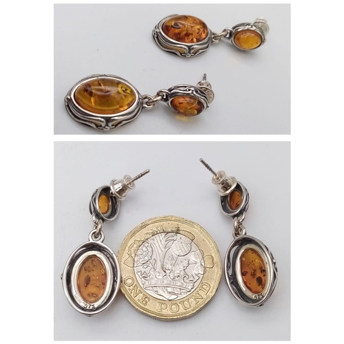 1385 - An Amber Oval Cabochon Pendant and a Pair of Amber Drop Earrings. All items set in 925 silver. Penda... 