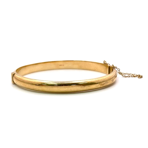 1483 - A Vintage 9K Yellow Gold Clip Bangle - with safety chain. Full UK hallmark. 6cm inner diameter. 8.45... 