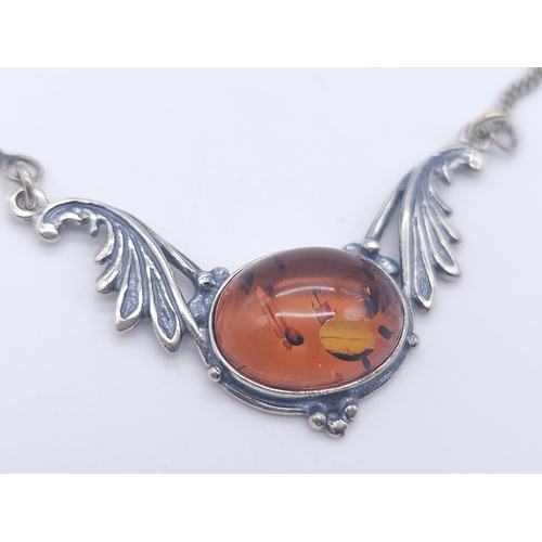 1504 - A 925 Silver Necklace with Amber Lavaliere. Amber cabochon central to two decorative wings. 42cm. 6.... 