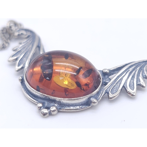 1504 - A 925 Silver Necklace with Amber Lavaliere. Amber cabochon central to two decorative wings. 42cm. 6.... 