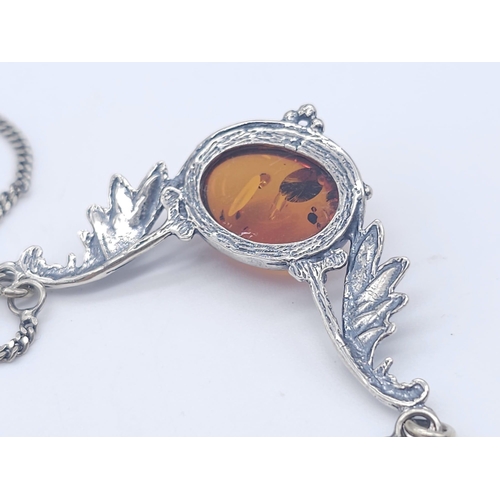 1504 - A 925 Silver Necklace with Amber Lavaliere. Amber cabochon central to two decorative wings. 42cm. 6.... 