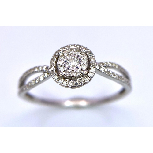 1415 - A 9K White Gold Diamond Double Halo Ring. Central diamond with double diamond halo and shoulder acce... 