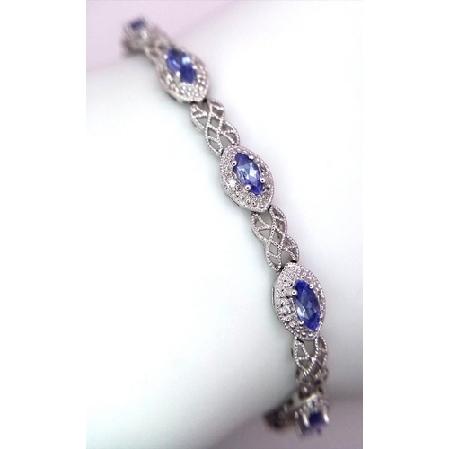 1478 - A 9K White Gold, Purple Sapphire and Diamond Tennis Bracelet. Eye-shaped links with sapphire centres... 