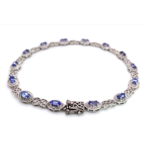 1478 - A 9K White Gold, Purple Sapphire and Diamond Tennis Bracelet. Eye-shaped links with sapphire centres... 