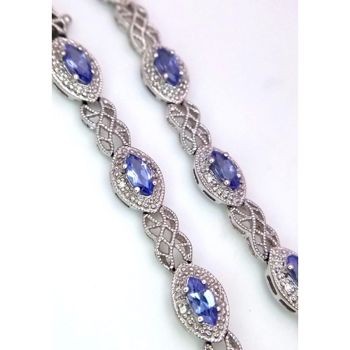 1478 - A 9K White Gold, Purple Sapphire and Diamond Tennis Bracelet. Eye-shaped links with sapphire centres... 