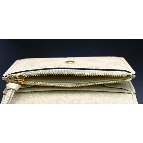 1604 - A Louis Vuitton Beige Leather Purse/Wallet. Decorative monogram exterior. Zipped inner compartment. ... 