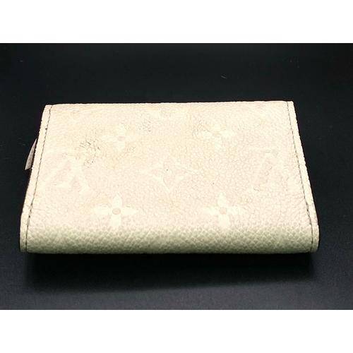 1604 - A Louis Vuitton Beige Leather Purse/Wallet. Decorative monogram exterior. Zipped inner compartment. ... 