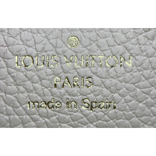 1604 - A Louis Vuitton Beige Leather Purse/Wallet. Decorative monogram exterior. Zipped inner compartment. ... 