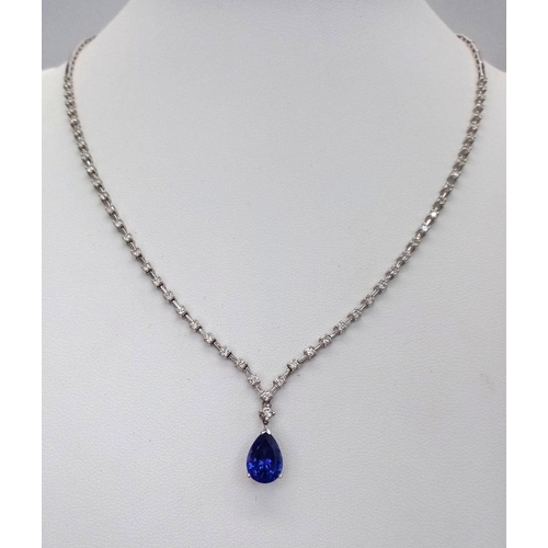 1681 - An 18kt White Gold, Diamond Necklace featuring a stunning Blue Sapphire. The 40cm necklace begins wi... 