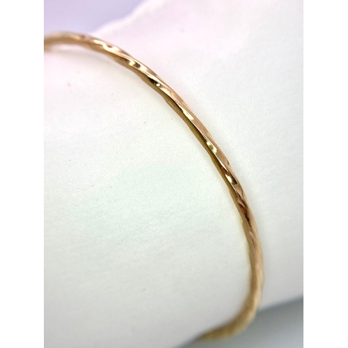 548 - A 9K Yellow Gold Bangle with Twist Decoration. 62mm inner diameter. 7.2g weight.