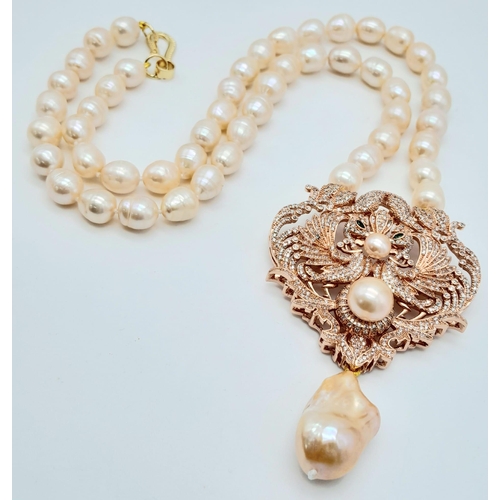 175 - A fabulous natural pearl necklace with a statement pendant loaded with cubic zirconia and a large ba... 