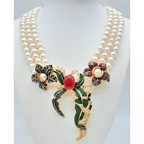 217 - A show stopping three strand natural pearl necklace with a substantial multi gem central pendant par... 