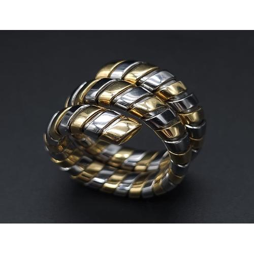 23 - A Bulgari Tubogas Flexible 18K Gold Ring. 16 yellow gold pipe bands alternate with stainless steel b... 