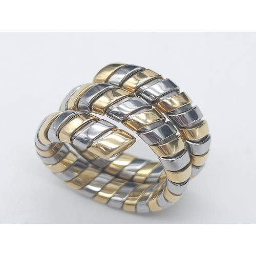 23 - A Bulgari Tubogas Flexible 18K Gold Ring. 16 yellow gold pipe bands alternate with stainless steel b... 