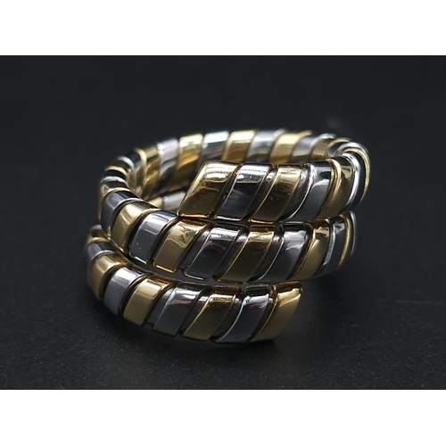 23 - A Bulgari Tubogas Flexible 18K Gold Ring. 16 yellow gold pipe bands alternate with stainless steel b... 