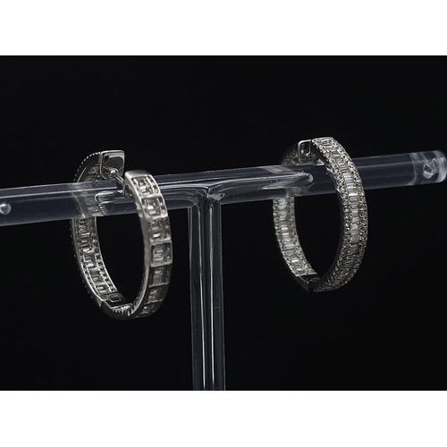 43 - A Pair of 18K White Gold 2ctw Diamond Hoop Earrings. An exquisite combination of baguette and round ... 