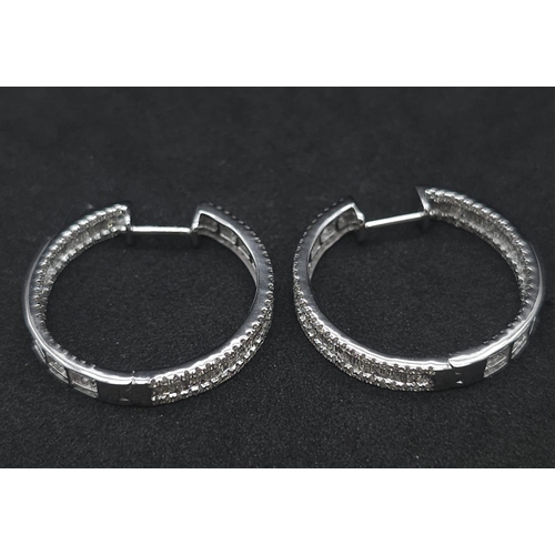 43 - A Pair of 18K White Gold 2ctw Diamond Hoop Earrings. An exquisite combination of baguette and round ... 