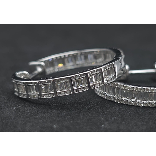 43 - A Pair of 18K White Gold 2ctw Diamond Hoop Earrings. An exquisite combination of baguette and round ... 