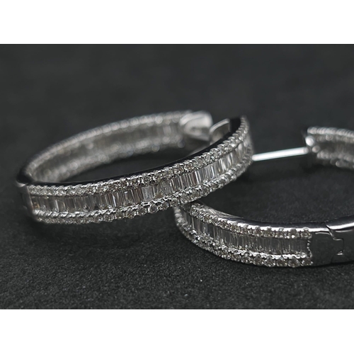 43 - A Pair of 18K White Gold 2ctw Diamond Hoop Earrings. An exquisite combination of baguette and round ... 