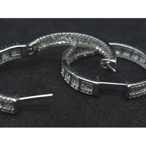 43 - A Pair of 18K White Gold 2ctw Diamond Hoop Earrings. An exquisite combination of baguette and round ... 