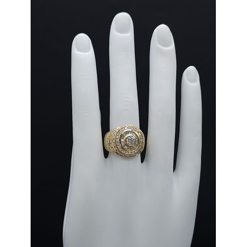 93 - An 18K Yellow Gold and Diamond Bullseye Dress Ring. A central brilliant round cut diamond surrounded... 