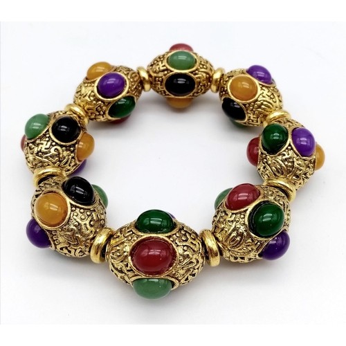 829 - A Gilded Tibetan Style Bracelet with Multi-Colour Jade Cabochon Decoration. Gilded spacers. Expandab... 