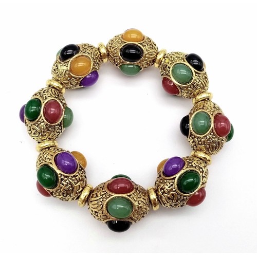 829 - A Gilded Tibetan Style Bracelet with Multi-Colour Jade Cabochon Decoration. Gilded spacers. Expandab... 