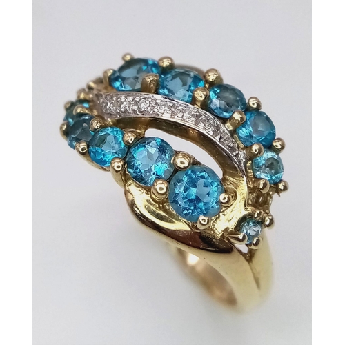 1087 - A 9K Yellow Gold Topaz and Diamond Swirl Ring. Size Q/R. 3.95g total weight.