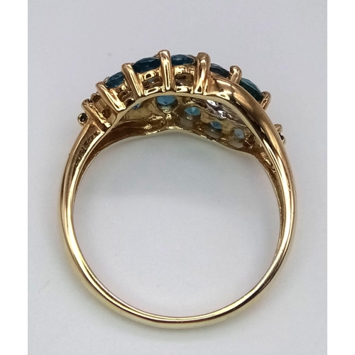 1087 - A 9K Yellow Gold Topaz and Diamond Swirl Ring. Size Q/R. 3.95g total weight.