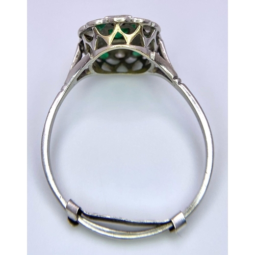 1226 - A 9K White Gold Emerald and Diamond Ring. Square cut emerald with a diamond and emerald halo. Size X... 