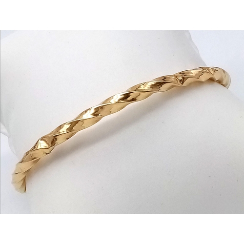 1556 - A 9K Yellow Gold Twist Bangle. 3.22g weight.