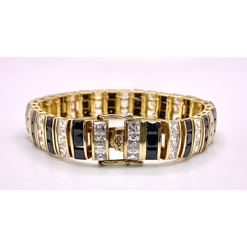 985 - A fancy 925 gilded silver black & white Zirconia bracelet. Total weight 41.8G. Total length 22cm.