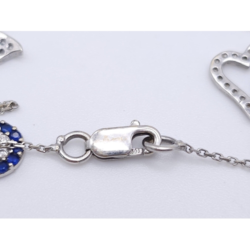 1038 - A 14kt White Gold Diamond Set Charm Bracelet.
Variety of charms, this bracelet measures 16cm in leng... 