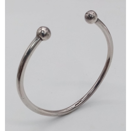 1566 - A vintage sterling silver Torque bangle. Total weight 23.35G. Widest inner length 6cm.