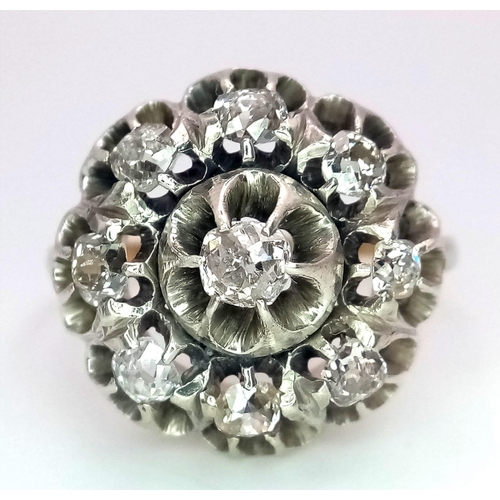 191 - An 18K Yellow and White Gold Diamond Ring. Central brilliant round cut diamond with an eight brillia... 