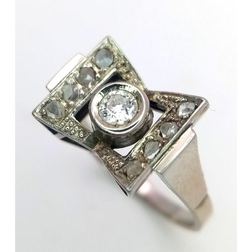 506 - An 18K White Gold (tested) Art Deco Style Diamond Ring. Central brilliant round cut diamond with a b... 