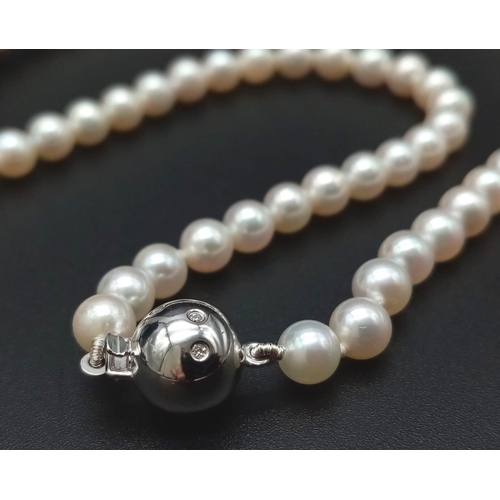 653 - A Wonderful South Sea, White Pearl Necklace with a Tahitian Black Pearl and Diamond Centrepiece. 750... 