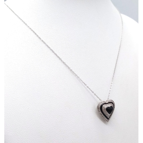 691 - An 18K White Gold Diamond and Black Onyx Heart Pendant on a 9K White Gold Disappearing Necklace. Pen... 